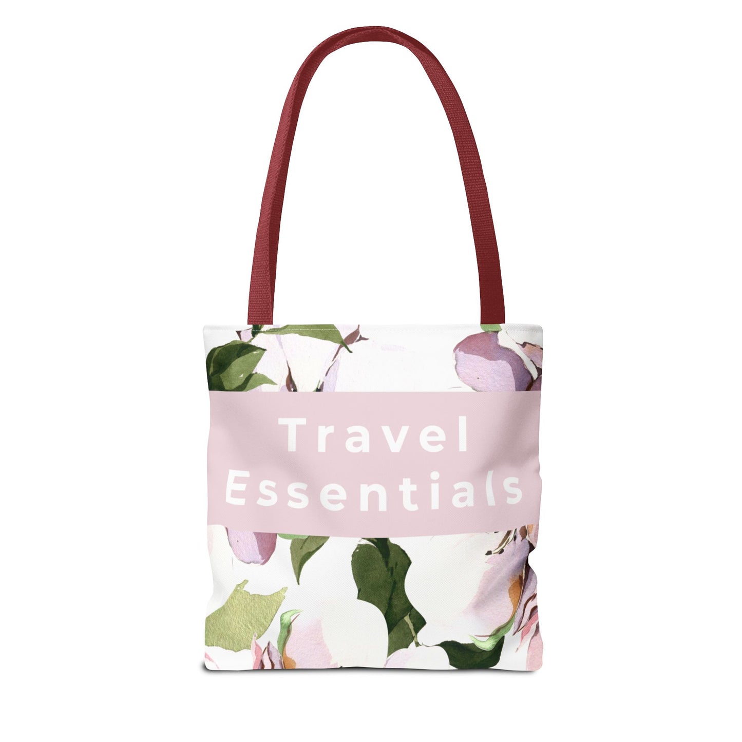 Floral canvas tote bag with “Travel Essentials” text and black handles front view
