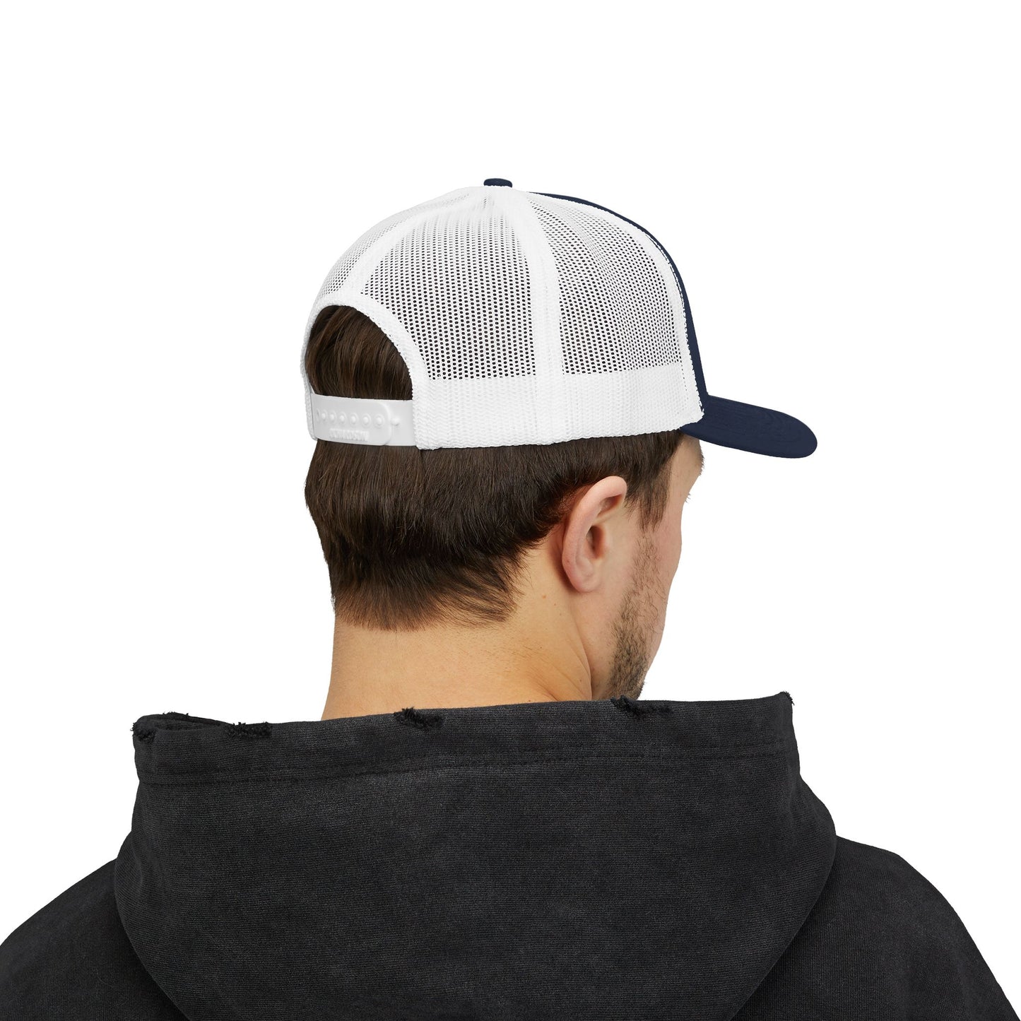 Person wearing  a white and navy trucker cap on a white background