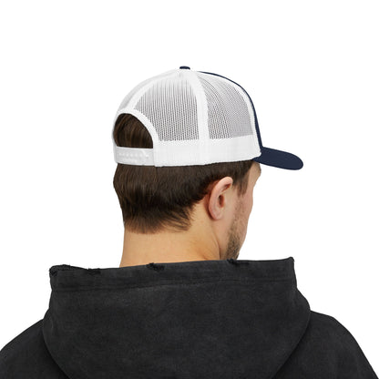 Person wearing  a white and navy trucker cap on a white background