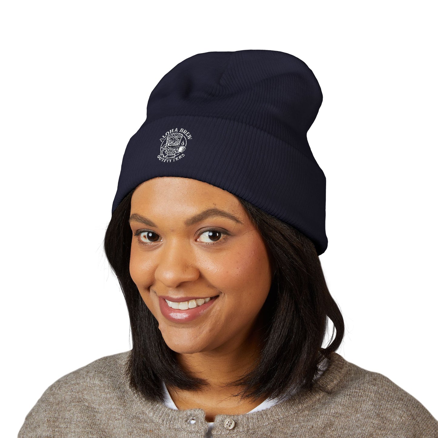 Person wearing a navy blue beanie with a logo on a white background