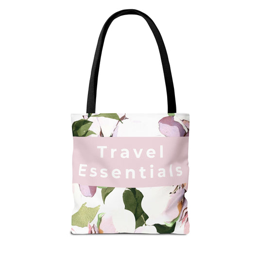 Floral canvas tote bag with “Travel Essentials” text and black handles front view
