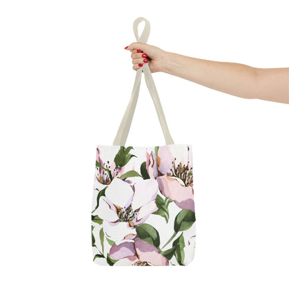 Tote bag with floral design held by a hand on a white background